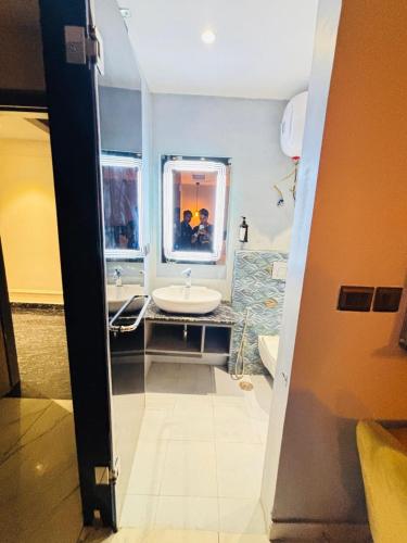 a bathroom with a sink and a mirror at Staylo Hotel Azora in New Delhi