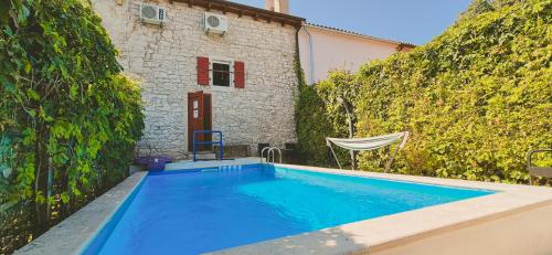 a swimming pool in front of a house at Istria Stone House in Marasi