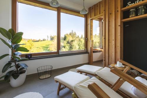 a room with a table and chairs and windows at Lill' Hill estate & wellness - Lumina Chalet in Idrija