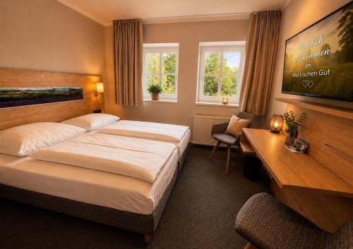 a hotel room with a bed and a desk at Hotel Maucksches Gut in Freiberg