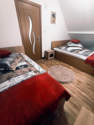 a bedroom with two beds and a wooden floor at Cabana Geta&Mircea in Beclean