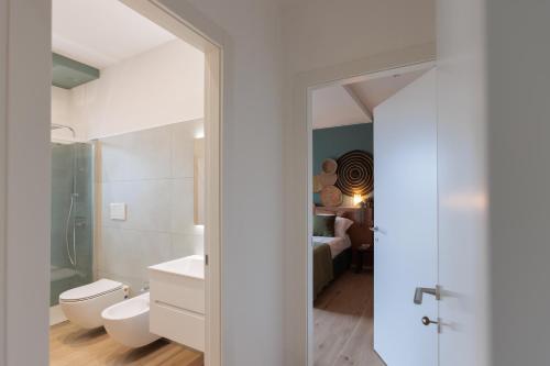 a white bathroom with a toilet and a sink at Dimore Tinè in Castellana Grotte