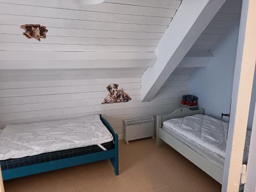 two beds in a room with white walls at Gite le Buron in La Bourboule