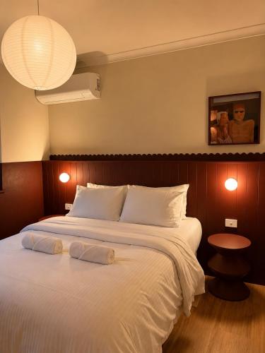 a bedroom with a large bed with two towels on it at The Bron Apartment - newly renovated, designer stay in Yarralumla