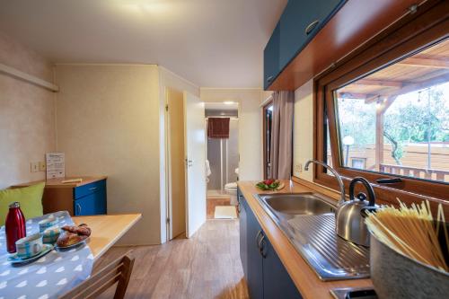a small kitchen with a sink and a window at Camping Village Il Poggetto in Troghi