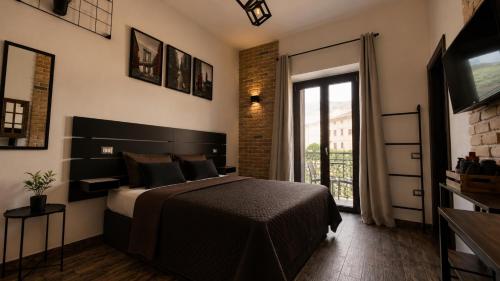 a bedroom with a bed and a large window at LoFT in Bosa