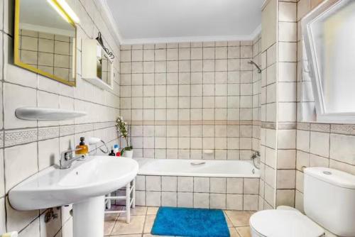 a bathroom with a sink and a tub and a toilet at Dhara Wellness Villa in Benirrama