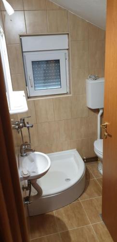 a bathroom with a sink and a toilet and a window at Villa Natalija in Andrijevica