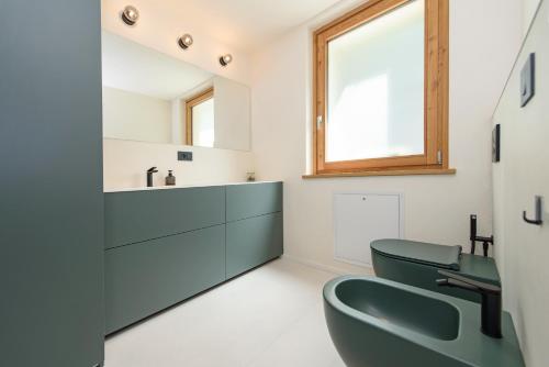 a bathroom with a green toilet and a sink at "Lomà" - Aosta Valley EcoResort in Champdepraz