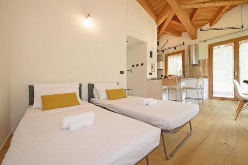 two beds in a room with wooden ceilings at "Lomà" - Aosta Valley EcoResort in Champdepraz