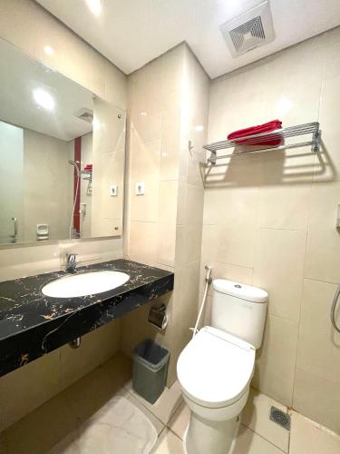 a bathroom with a white toilet and a sink at Brothers Inn Babarsari in Yogyakarta