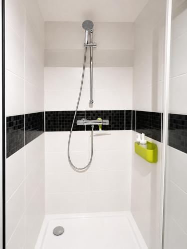 a shower in a bathroom with black and white tiles at Piscine et pétanque - Calme proche Belfort in Châlonvillars