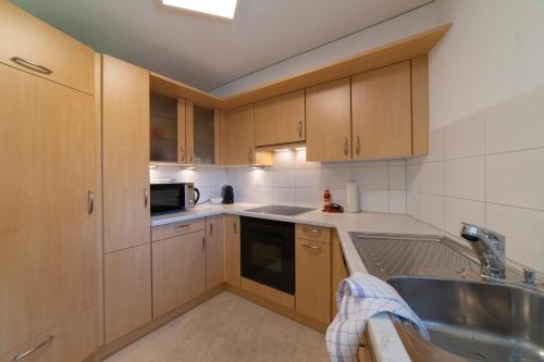 a kitchen with wooden cabinets and a sink at Bruno in Unterwasser