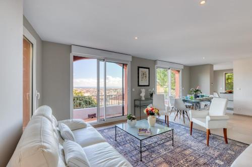 a living room with a white couch and a table at Villa sur les hauteurs de Nice, proche centre in Nice