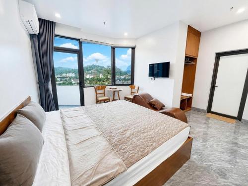 a bedroom with a large bed and a large window at Như Ý Hotel Hà Giang in Ha Giang