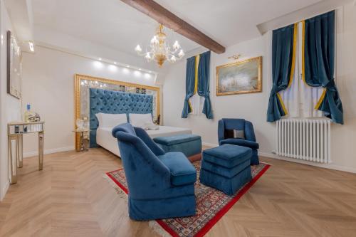 a bedroom with a bed and two blue chairs at Ca Dell'Arte in Venice