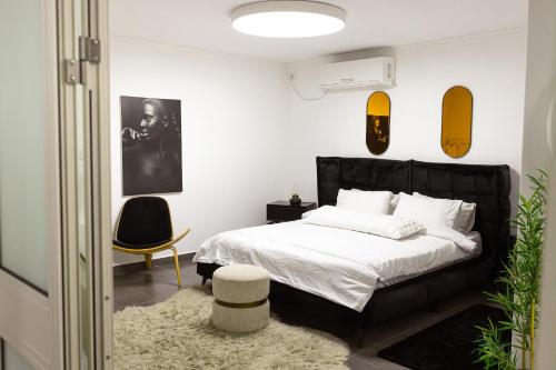 a bedroom with a black bed and a black chair at סוויטת רגעים Regaim צימר בוטיק בגליל העליון in Sede Eli‘ezer