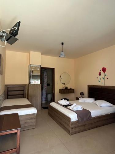 a bedroom with two beds and a table and a mirror at House Stamatis in Sarti