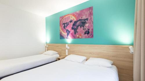 two beds in a room with a painting on the wall at Kyriad ECO - Dijon Sud Chenove in Chenôve