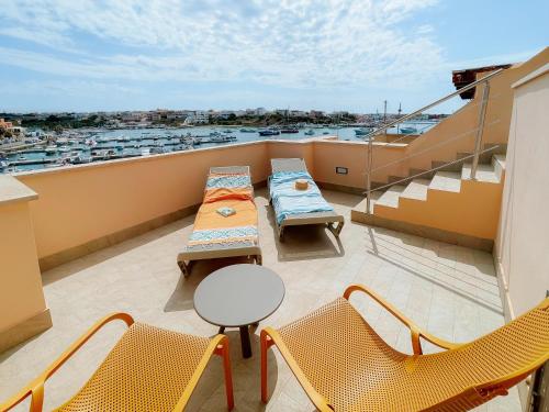 a balcony with tables and chairs and a view of a harbor at Best Western Hotel Martello in Lampedusa