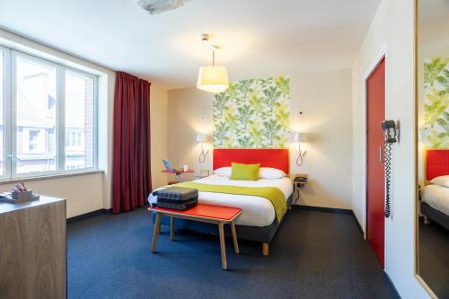 a hotel room with a bed and a table at ibis Styles Calais Centre in Calais
