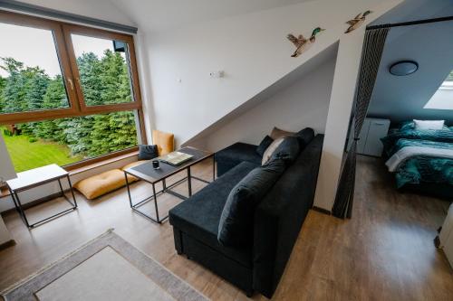 a living room with a couch and a large window at VISTA Necko - apartament nad jeziorem Augustów in Augustów