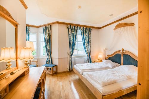 a bedroom with two beds and two windows at NaturResidence Dolomitenhof in Siusi