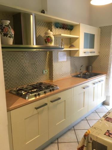 a kitchen with white cabinets and a stove at Modì Apartment in Rome