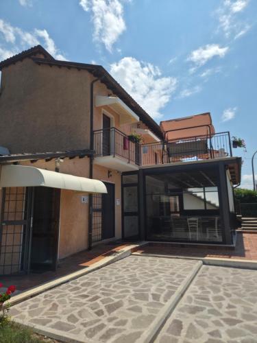a house with a balcony with a chair on it at Volo Libero - Guest House in Poggio Bustone