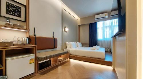 a hotel room with a bed and a window at Marwin Villa in Bangkok