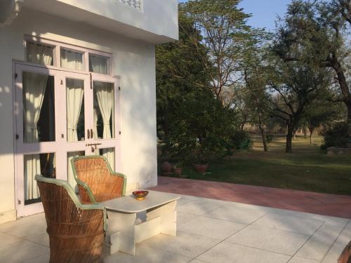 a white house with a chair and a table on a patio at Savista Retreat in Jaipur