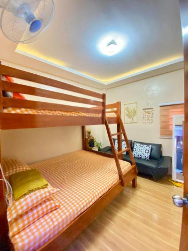a bedroom with a bunk bed and a couch at Second Pad at Second floor in Bolinao