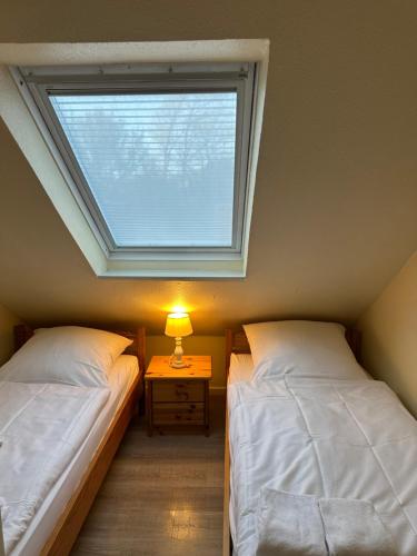 a bedroom with two twin beds and a window at Landhaus Gerdts - 2 in Cuxhaven
