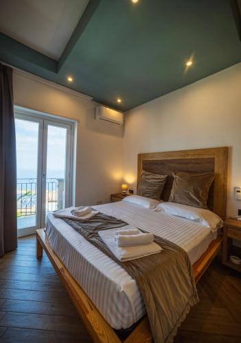 ein Schlafzimmer mit einem großen Bett und einem großen Fenster in der Unterkunft Suite Pizzo jacuzzi rooms in Pizzo