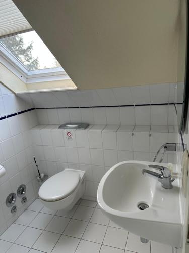 a white bathroom with a sink and a toilet at Landhaus Gerdts - 2 in Cuxhaven