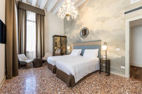a bedroom with a large bed and a chandelier at Ca' Del Campo in Venice