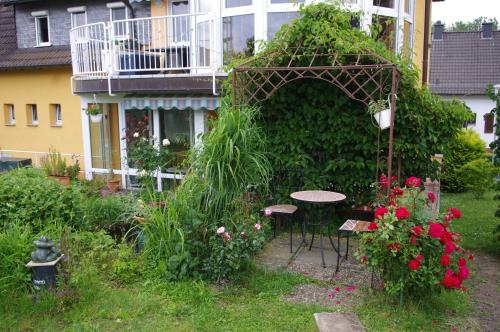 einen Garten mit einem Tisch und Stühlen vor einem Gebäude in der Unterkunft Ferienwohnung Bischoff in Michelstadt