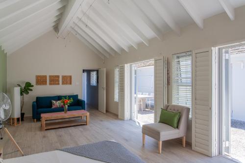 a living room with a blue couch and chairs at The Barn Style Cottage in Cape Town