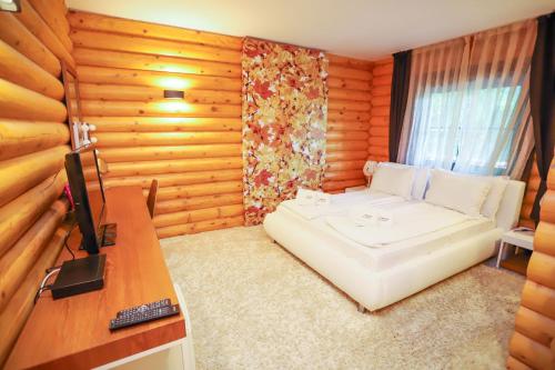 a room with a bed and a desk with a television at Deluxe House Glavatarski Han in Glavatartsi