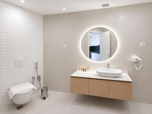 a bathroom with a sink and a toilet and a mirror at Sobre Suites in Bečići