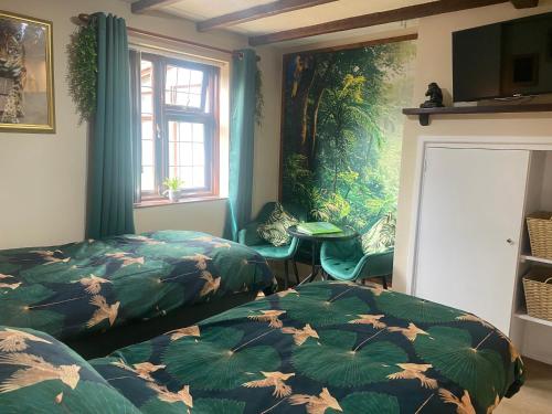 a bedroom with two beds and a painting on the wall at Jungle Lodge in Rustington