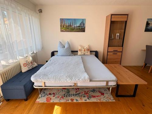 a bedroom with a large bed and a blue couch at Höri-Nest Wohlfühl-Appartement in Gaienhofen