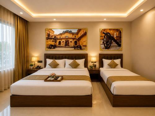 two beds in a hotel room with paintings on the walls at Lime Tree Hotel & Banquet Jal Mahal Jaipur in Jaipur