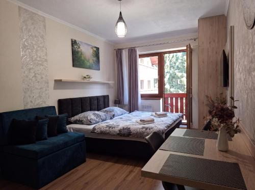 a living room with a bed and a couch at Apartments 17 - 23 AD Kamzík in Donovaly