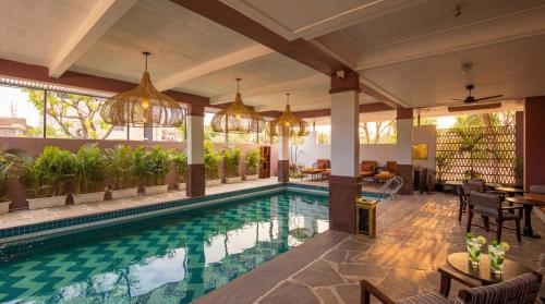 a swimming pool in a house with chandeliers at The Sierra - By The Lake in Udaipur