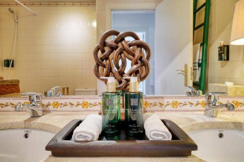 a bathroom sink with a statue of a pretzel at bwelcome aroeira beach & golf in Charneca
