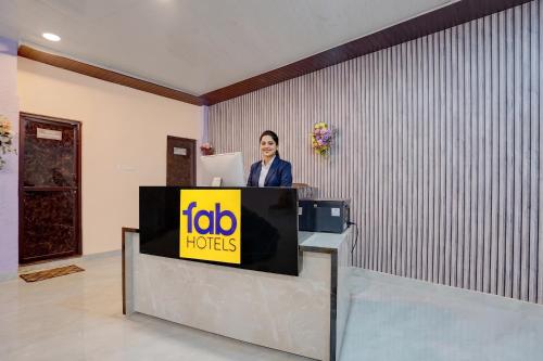 a woman is standing behind a sign on a desk at FabHotel Crystal Zee in Kānpur