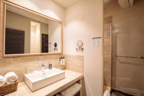 a bathroom with a sink and a mirror at Boutique Hôtel La Villa Montesquieu & sa piscine in Laudun