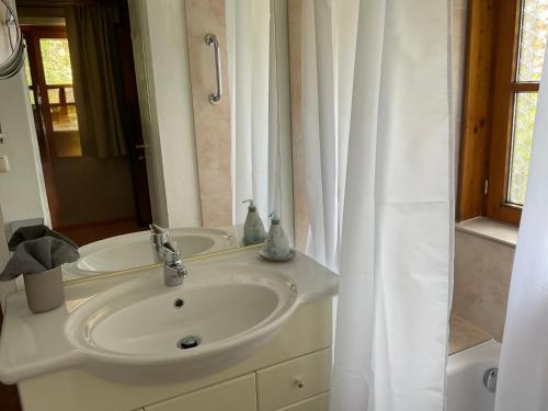 a white bathroom with a sink and a shower at Haus Louise in Reit im Winkl