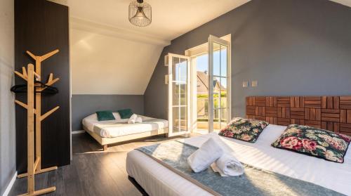 a bedroom with two beds and a large window at Villa Cerf - SPA Privé, Climatisation, Sauna, Borne d'arcade, Babyfoot in Ittenheim